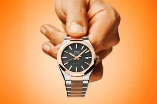 Mido Multifort 8 One Crown bitono con bisel octogonal en oro rosado y carátula negra mostrado en la mano de un caballero