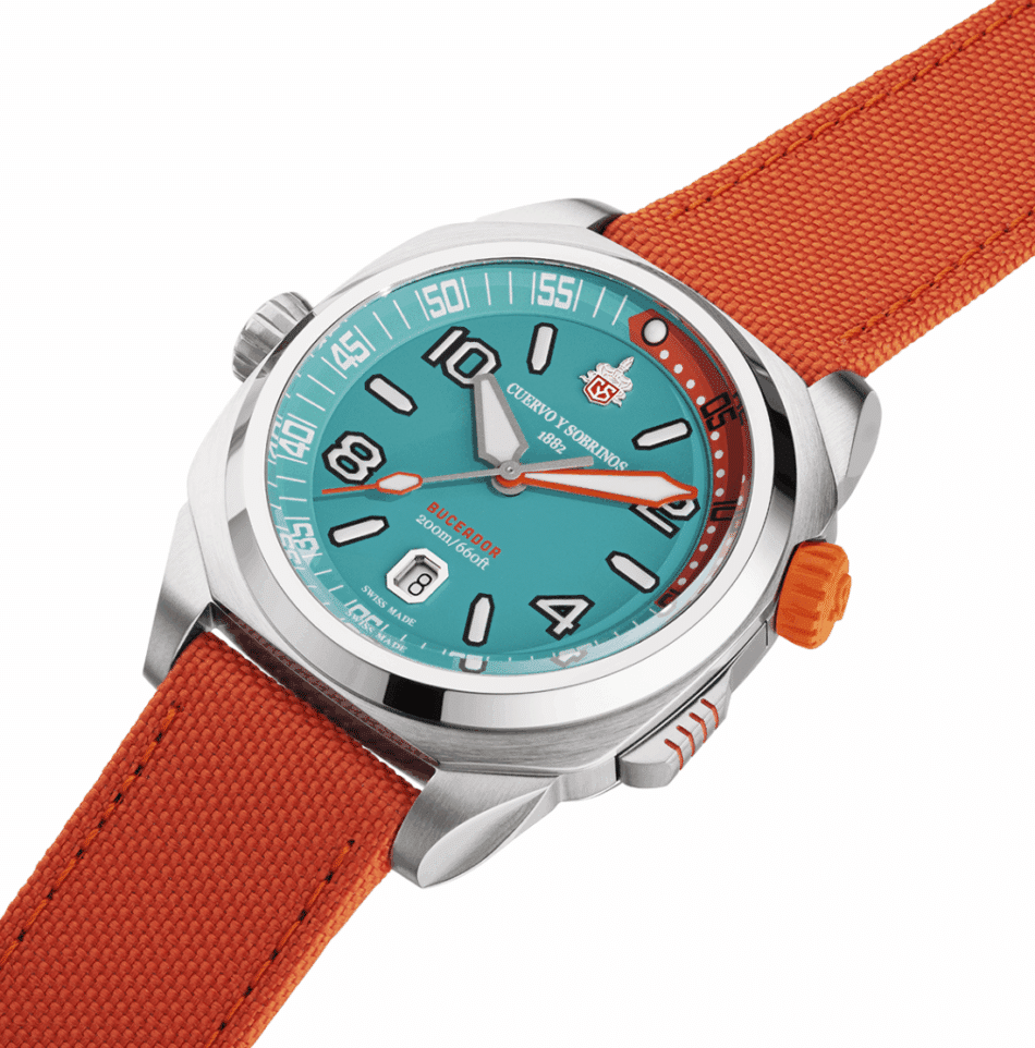 CUERVO Y SOBRINOSBuceador Caribenaranja de lado Watches World Reloj de pulsera de acero inoxidable con esfera turquesa números blanco y correa de cordura naranja corona naranja en el lateral imagen tomada desde un ángulo