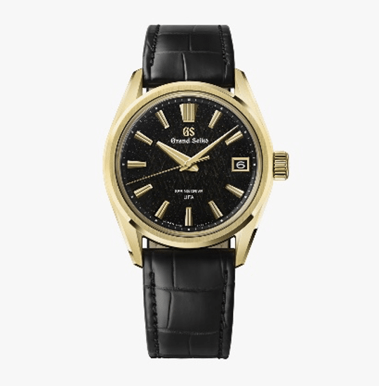 GRAND SEIKOBosque de hielo al amanecer SLGB006COMPLETO Watches World Gold tone wristwatch with black leather strap and a black textured dial date window at 3 oclock Grand Seiko branding on the face