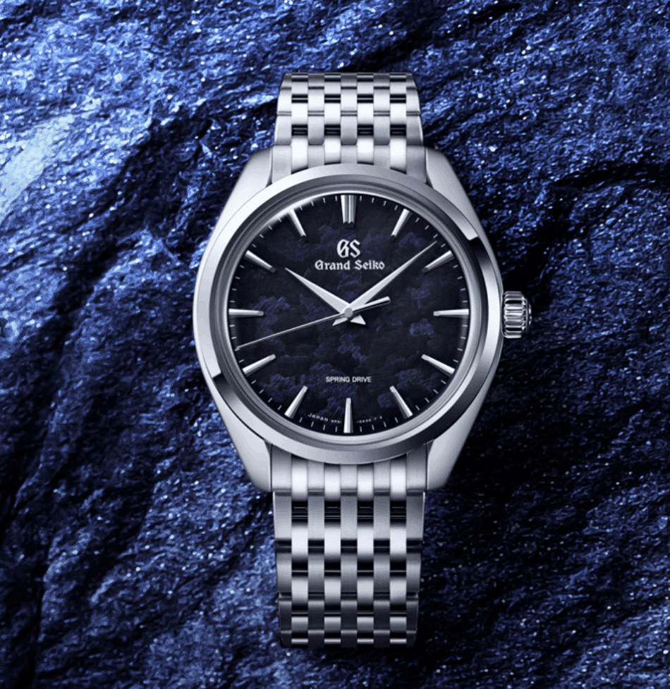 GRAND SEIKOIwao Azul SBGY043LIFESTYLE Watches World Silver Grand Seiko wristwatch with metal bracelet on a blue textured rock background close up
