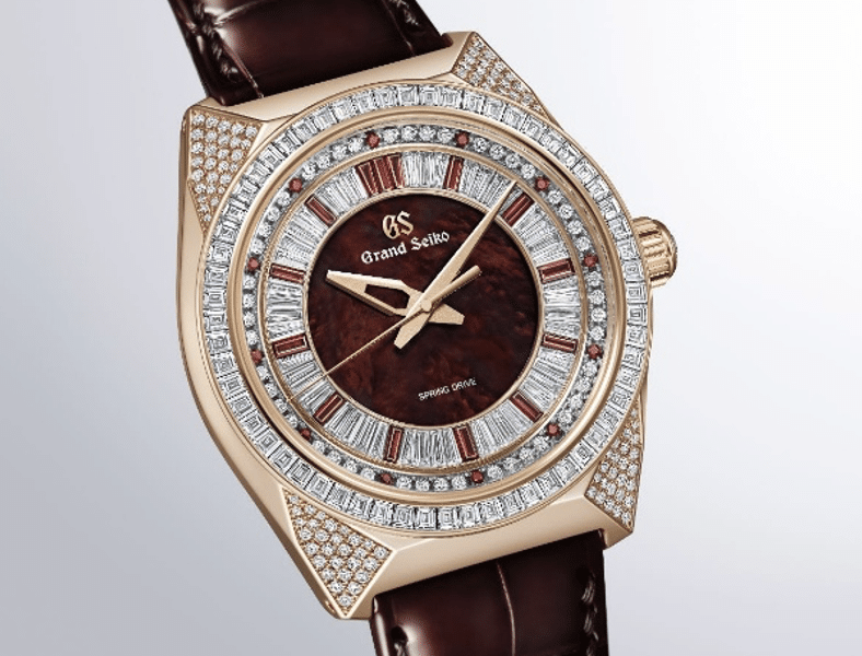 GRAND SEIKOMasterpiece Spring Drive León RojoCARÁTULA Watches World Gold watch with a diamond studded bezel and brown leather strap on a light background