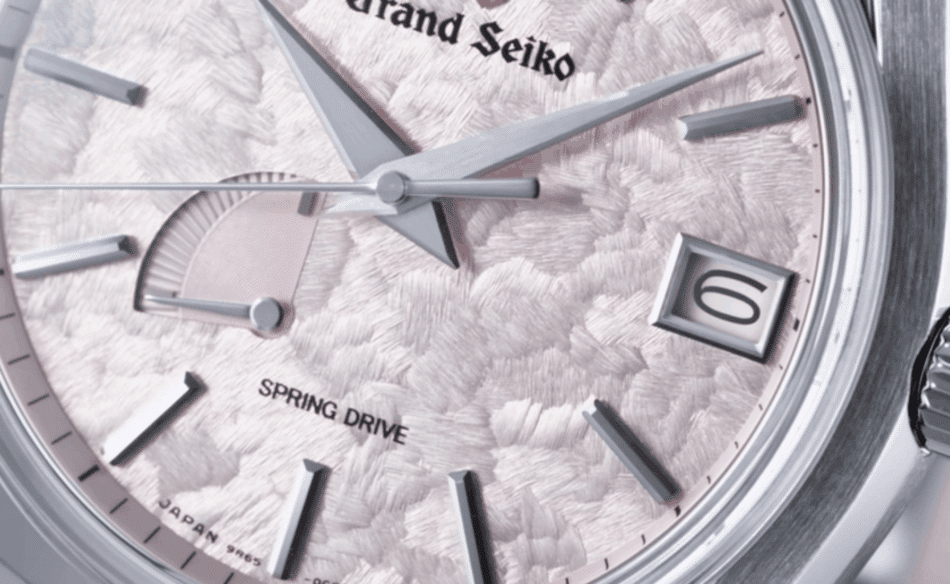 Grand Seiko 62GS Shunbun CLOSE UP CARATULA Watches World Close up of a pink textured watch dial with silver hands date window showing 6 and SPRING DRIVE text