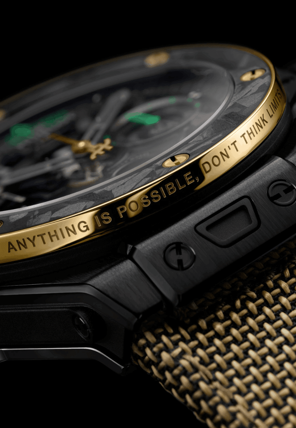 HUBLOTBig Bang Reloaded Usain BoltDETALLE Watches World Close up of a black luxury watch with a gold bezel engraved Anything is possible dont think limits on a woven strap