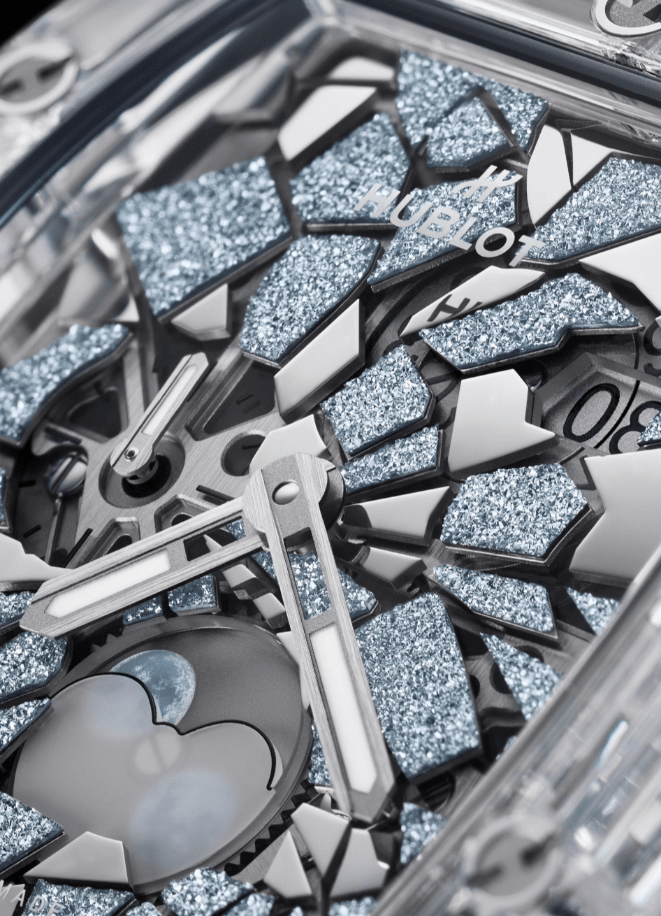 HUBLOTThe Spirit Of Big Bang ImpactDETALLE Watches World Close up of a shattered Hublot watch with glittery blue fragments and exposed metal hands