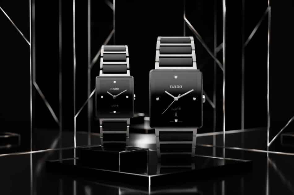 Rado Integral para mujer sofisticación suiza que permanece Watches World Dos relojes Rado Jubile con esfera cuadrada negra y correas de acero inoxidable sobre un pedestal de exhibición negro brillante