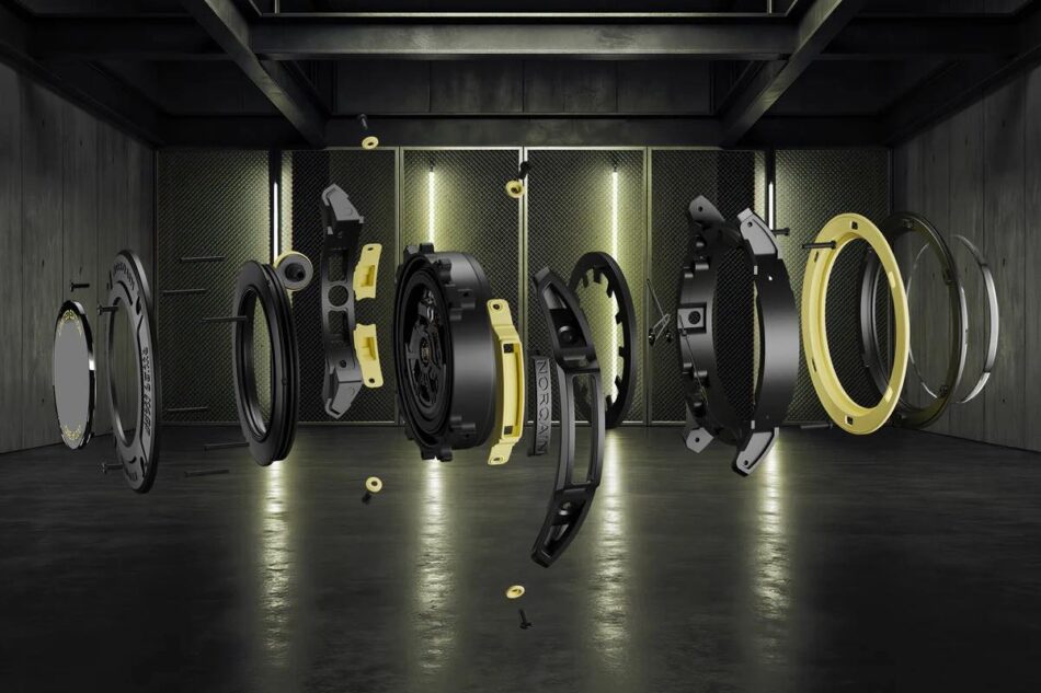 Norqain Wild ONE Skeleton XLite 6 Watches World Norqain Wild ONE Skeleton X Lite 3 NORTEQ el más ligero Exploded view of a luxury watch movement with black and gold components floating in a dark industrial setting