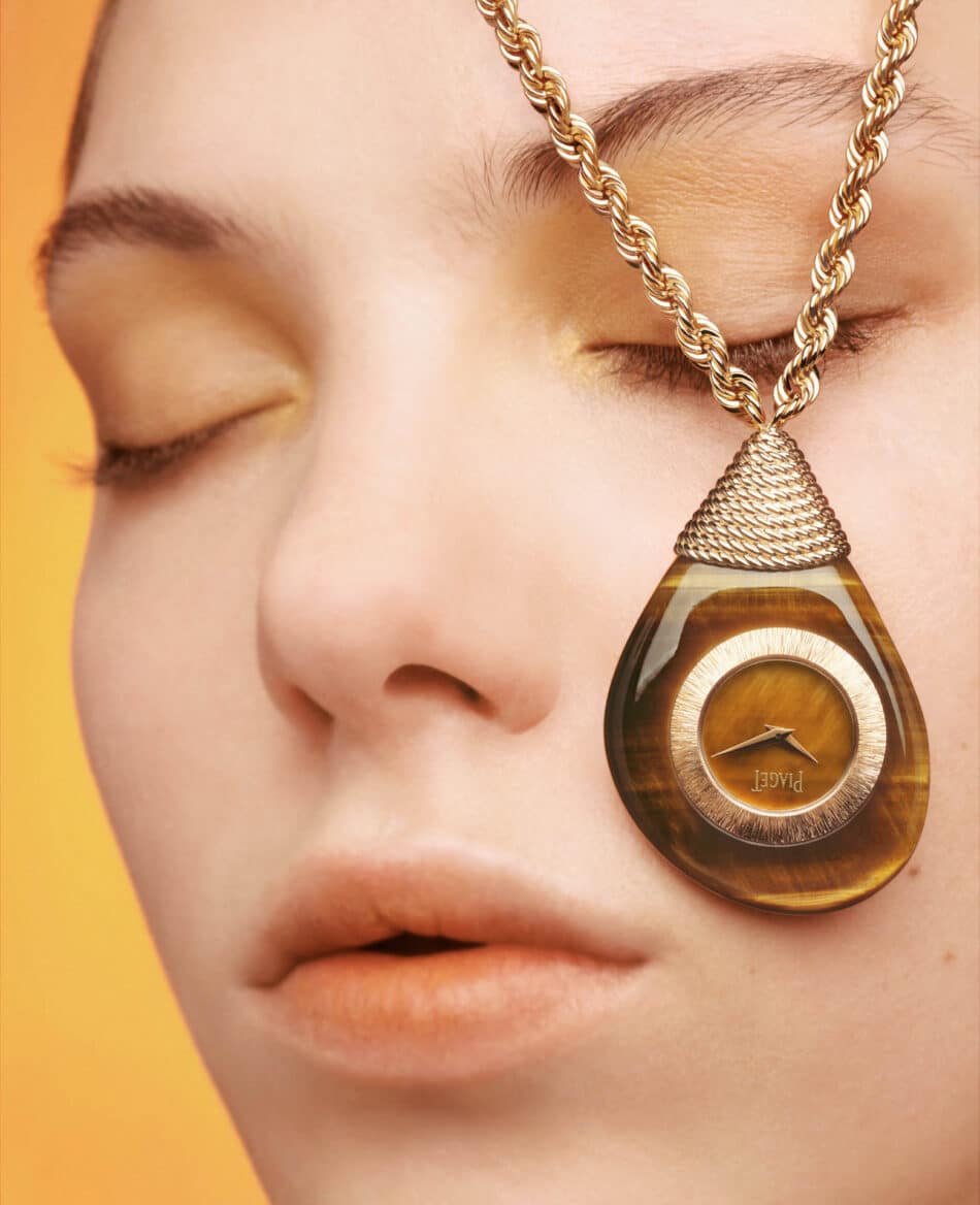 Piaget Swinging Pebbles el reloj sautoir que redefine el tiempo en 2026 Watches World Primer plano de una persona con los ojos cerrados que lleva un collar con un colgante dorado en forma de lágrima y una pieza central circular similar a un anillo