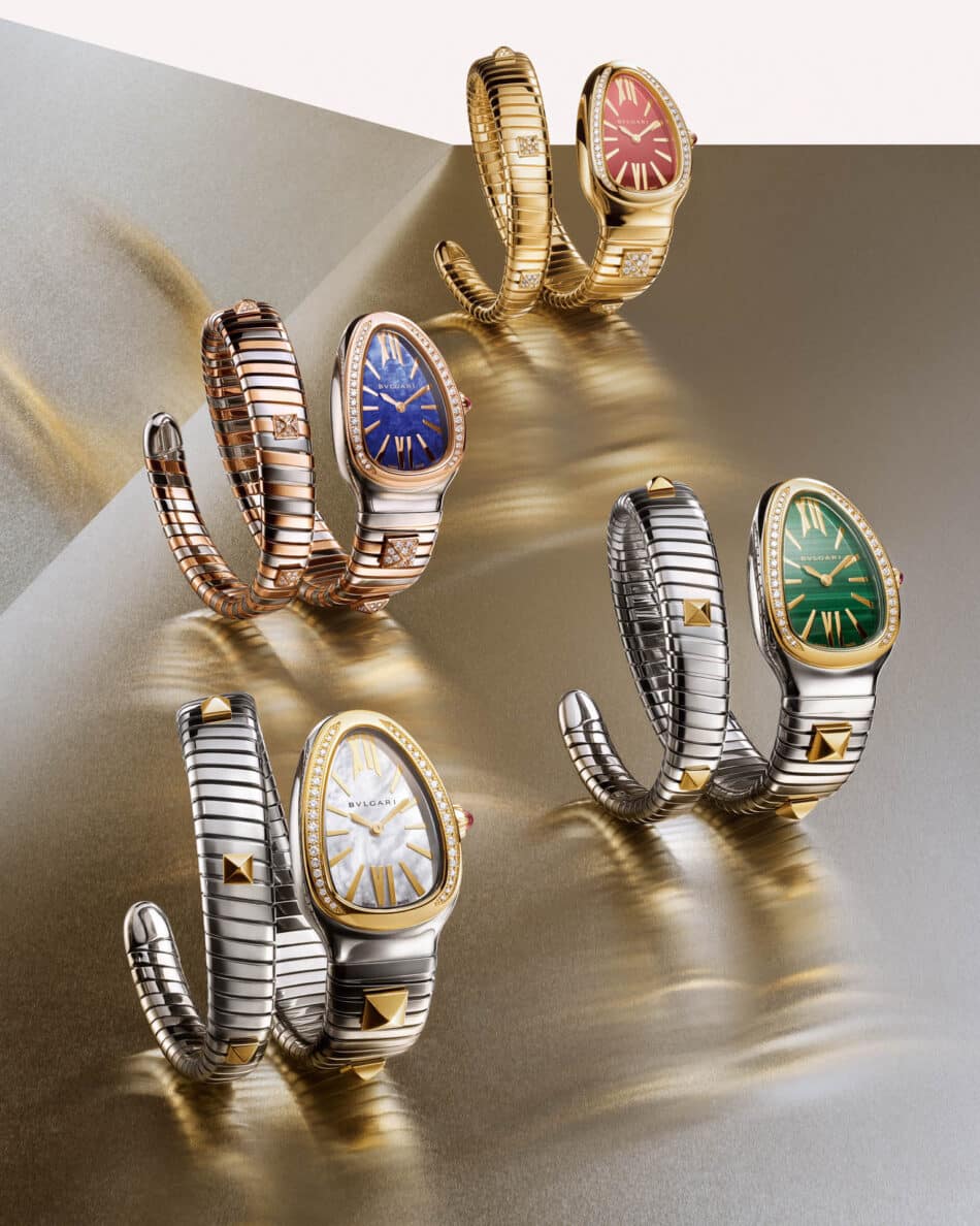 Serpenti Tubogas Studs 2 Watches World Varios relojes Bulgari Serpenti con brazaletes metálicos en espiral y esferas de colores rojo azul verde y blanco dispuestos sobre un fondo metálico con degradado