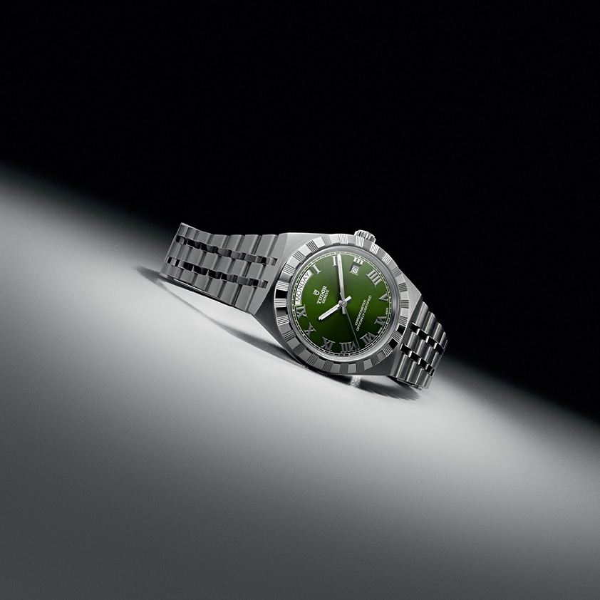 Tudor Royal con carátula verde y brazalete integrado de acero Watches World Reloj de pulsera de acero inoxidable con esfera verde colocado sobre una superficie blanca curvada sobre un fondo oscuro con un ángulo que le da un aspecto espectacular a la fotografía del producto