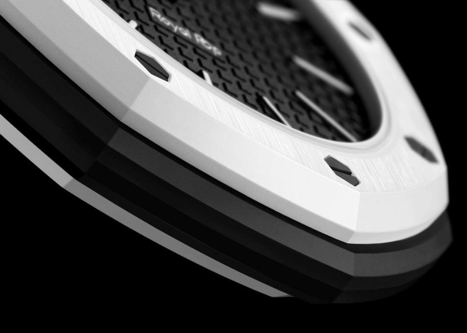 Audemars Piguet × SwatchOCHO NEGRO DETALLE CAJA Watches World Close up of a white electronic device front with a brushed metal finish black mesh grille and two small black buttons
