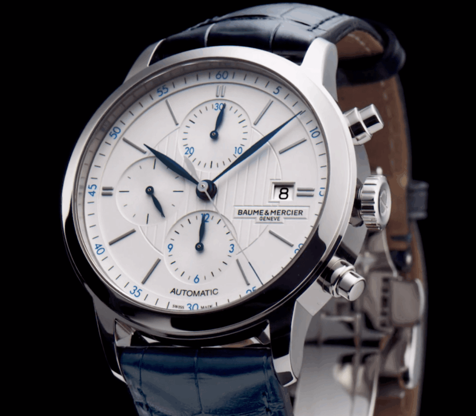 Baume Mercier Classima 10330FRENTE CERCA Watches World Primer plano de un cronógrafo automático de Baume Mercier con esfera blanca agujas azules y ventana de fecha sobre fondo negro