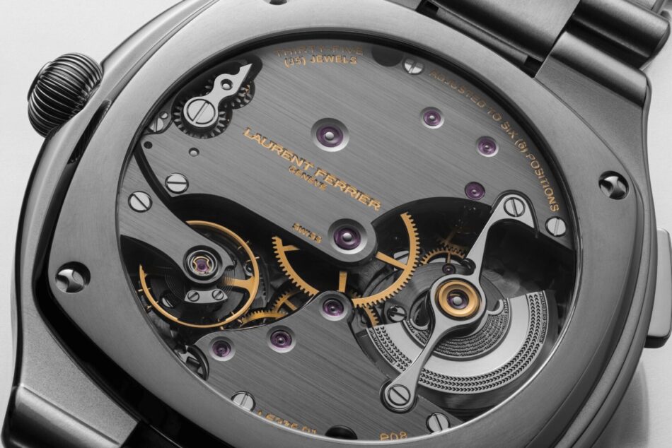 Laurent Ferrier Sport TravellerMECANISMO Watches World Close up of a luxury watch movement with gears and ruby jewels Laurent Ferrier Genève engraved on brushed metal