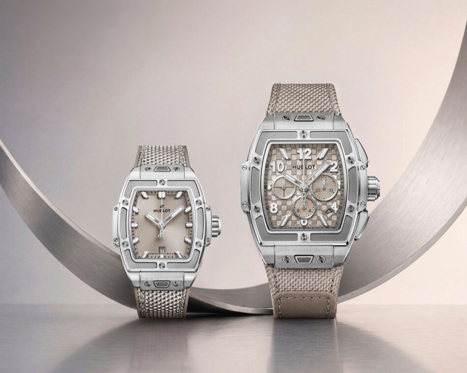 Spirit of Big Bang Essential Taupe 13 Watches World Two Hublot watches with square dials and metal woven bands resting on a curved brushed metal surface