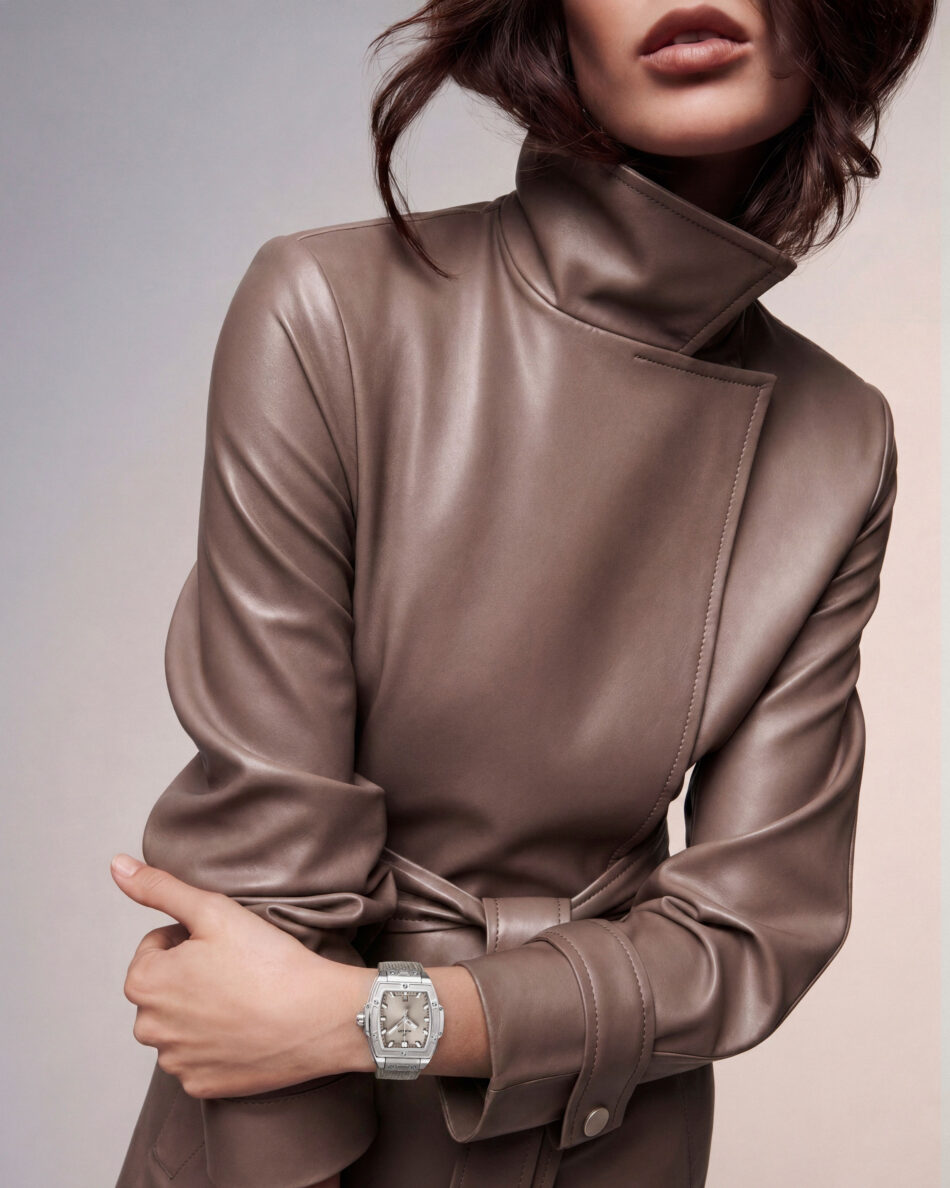 Spirit of Big Bang Essential Taupe 21 Watches World Close up of a person wearing a taupe leather coat with arms crossed and a silver wristwatch visible on the left wrist
