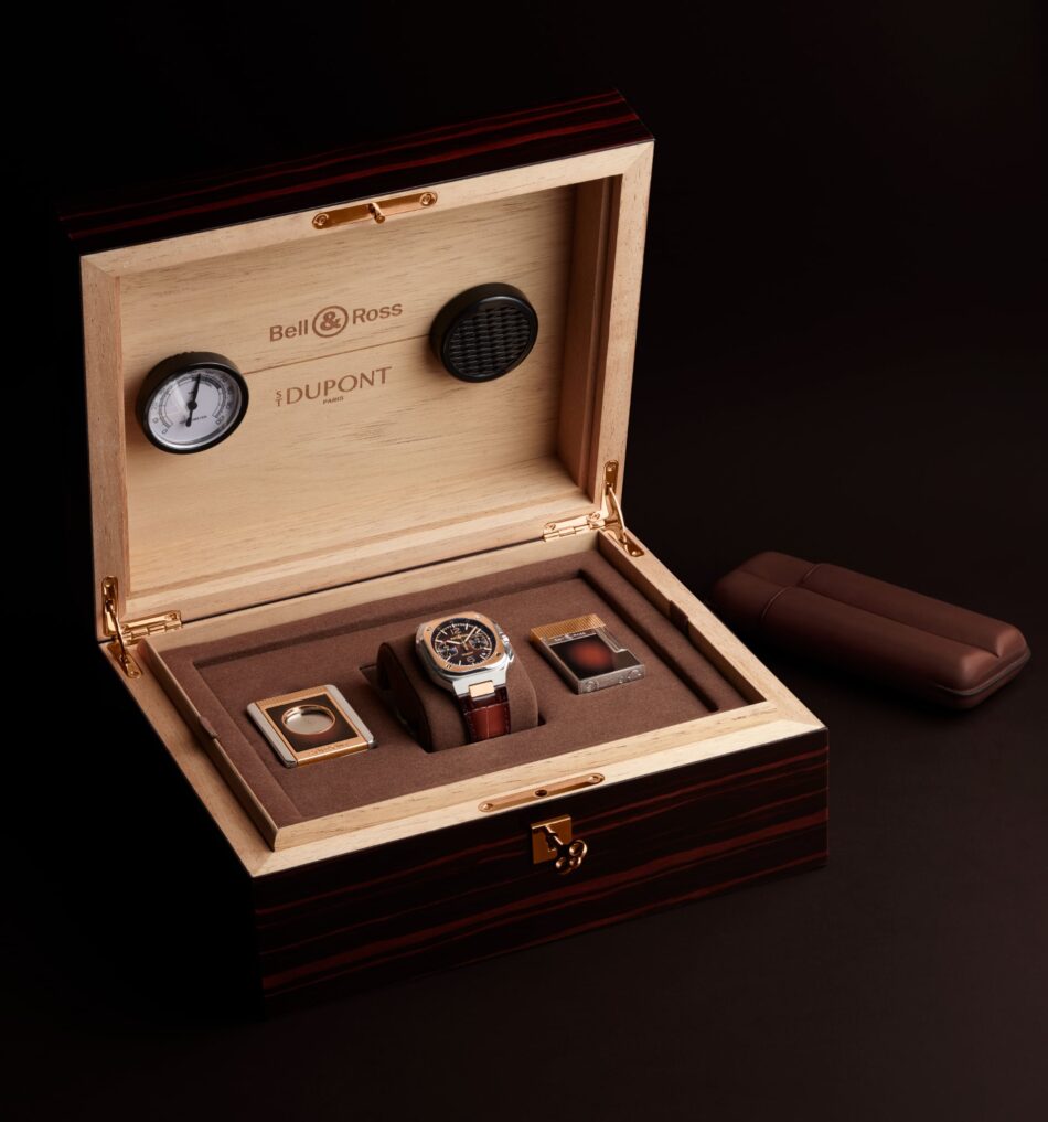 Bell Ross BR05 Chrono ST Dupont 1 Watches World Open wooden watch box displaying multiple luxury watches against a dark background with visible Bell Ross branding inside the lid