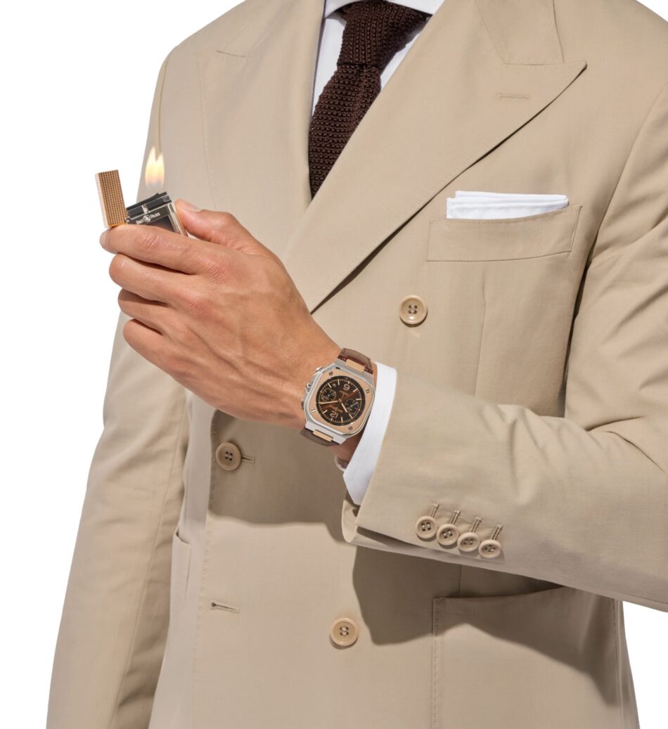 Bell Ross BR05 Chrono ST Dupont 2 Watches World Close up of a person in a beige suit holding a lighter with a small flame near the jacket also showing a brown tie and a silver wristwatch