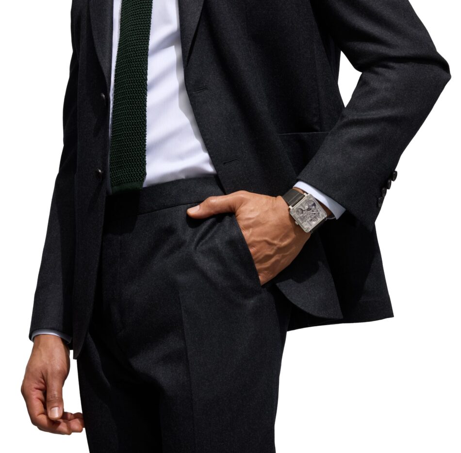 Bell Ross BRX3 MicroRotor Watches World Bell Ross BR X3 Micro Rotor Man in a dark suit with a green knit tie white shirt and crossed arms wearing a large silver wristwatch on his left wrist