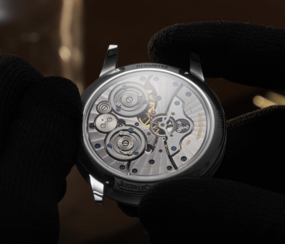 JaegerLeCoultre Duometre Heliotourbillon PerpetualFONDO DE CAJA Watches World Close up of a Jaeger LeCoultre Duomètre watch movement with gears and blue screws held by gloved hands