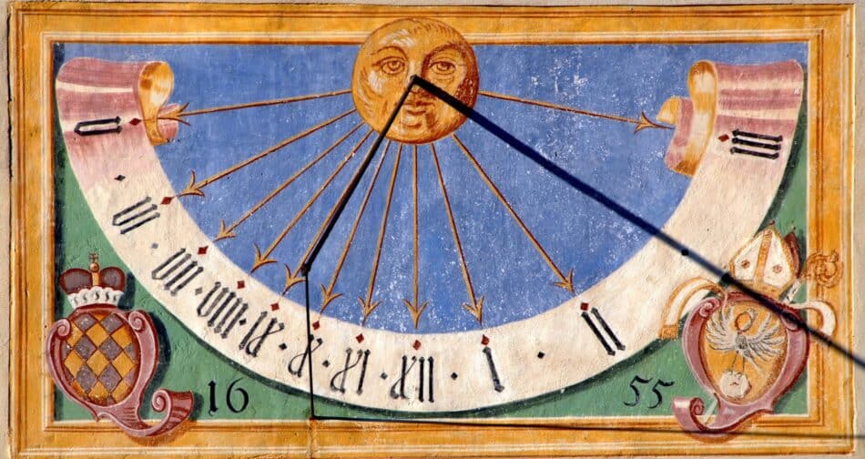 Reloj de sol de 1655Museo Virtual de la Ciencia 2 Watches World Decorative sundial panel sun at center with rays and an arcuate dial marked with hours against a blue sky