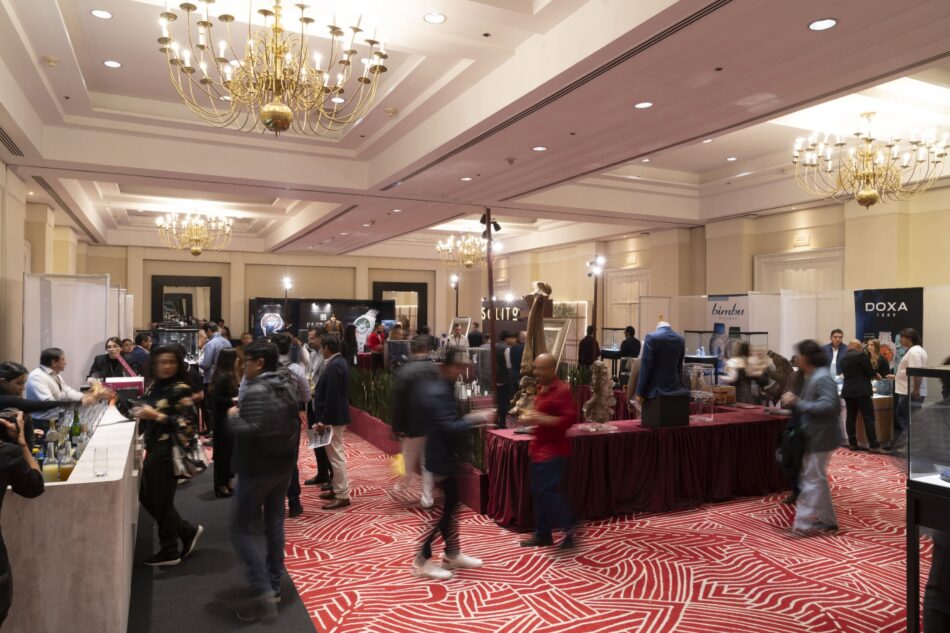 SIAR SUMMER 9 Watches World SIAR SUMMER Busy hotel style exhibition hall with booths attendees and red patterned carpet beneath ornate chandeliers