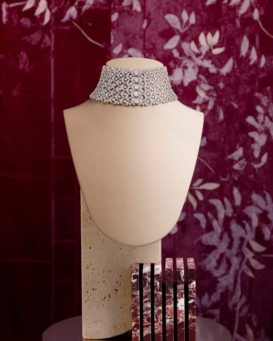 276466phAntonio Barrella4x5 Watches World Diamond encrusted choker necklace displayed on a beige mannequin bust against a burgundy patterned backdrop