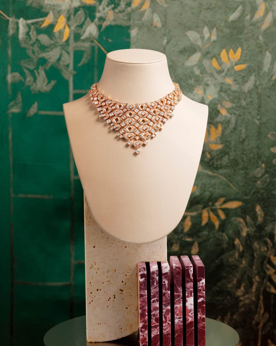 Gabarit en Ajour geometría convertida en luz Watches World Collar de diamantes con varias piedras de talla cuadrada sobre un busto de color crema con un fondo verde