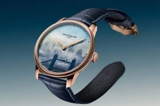 Rose gold watch with a blue leather strap and a pale blue dial featuring a London Tower Bridge scene.