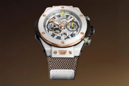 Skeleton chronograph watch with white case, rose-gold accents, and a woven metal strap showcasing exposed gears and dials.