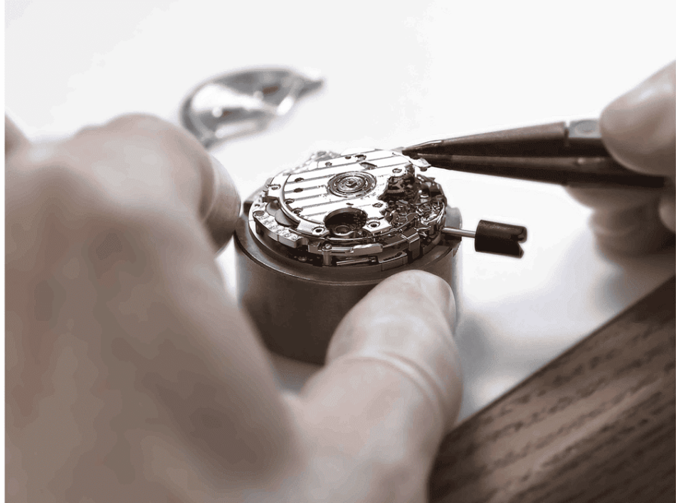 Calibre Spring Drive 9RB2 2 Watches World Calibre Spring Drive 9RB2 Watchmaker's hands using tweezers to work on a mechanical watch movement.