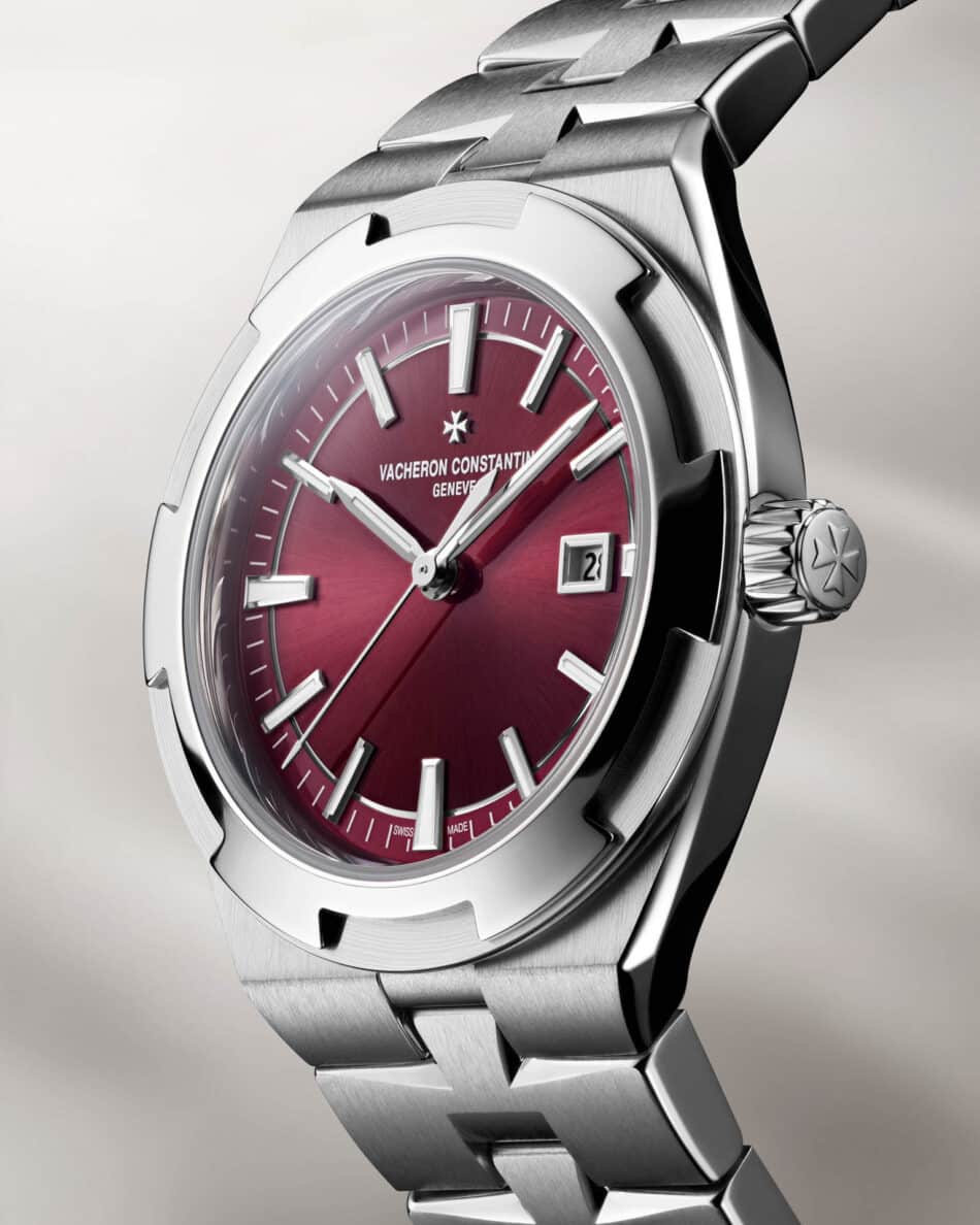 Vacheron Constantin renueva la colección Overseas con dos modelos automáticos de 345 mm Watches World Primer plano de un reloj de lujo de acero inoxidable con esfera de color burdeos índices horarios plateados y una ventanilla de fecha con la inscripción Vacheron Constantin Genève