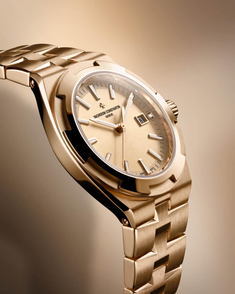 Vacheron Constantin renueva la colección Overseas con dos modelos automáticos de 345 mm Watches World Primer plano de un reloj de pulsera de lujo de oro con brazalete cepillado esfera beige y ventana de fecha que marca el 8