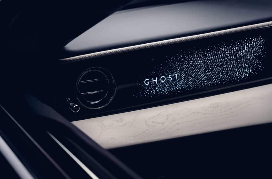 RollsRoyce Ghost Savile Row 5 Watches World Rolls Royce Ghost Savile Row Close up of a car dashboard with the illuminated'GHOST' branding and a circular gauge in a dark interior.