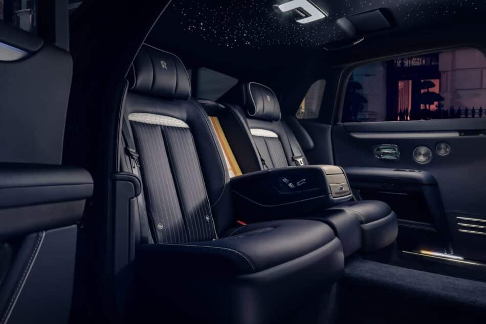 RollsRoyce Ghost Savile Row 8 Watches World Rolls Royce Ghost Savile Row Luxurious rear passenger seats in a dark leather car interior with a starry skylight Rolls Royce branding on headrests ambient lighting and chrome accents
